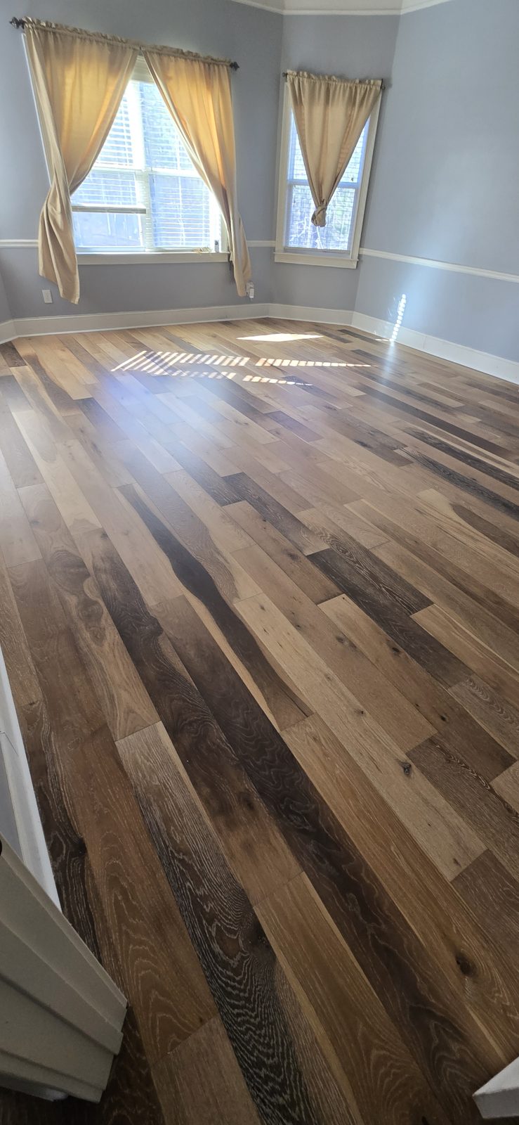 Wide-plank hardwood floor with dark stained accents